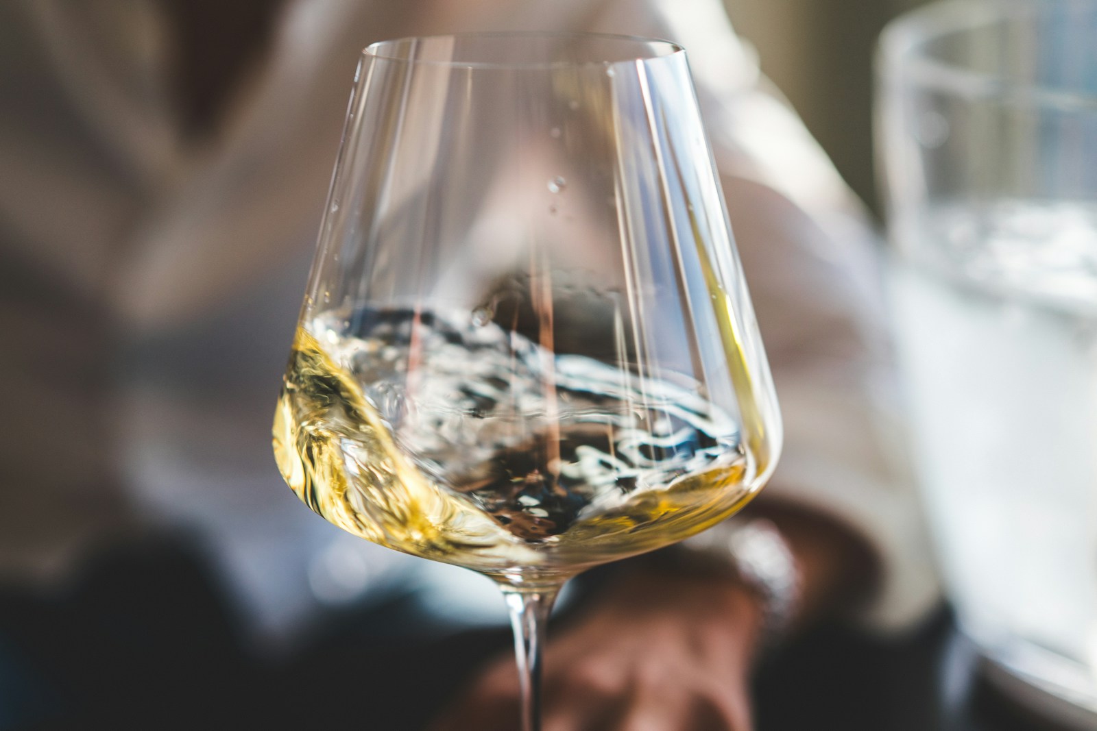 グラスの中で揺れる黄金色の日本酒。光が反射して涼やかな印象